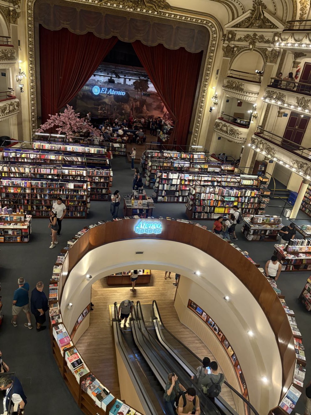 Bookshelves filling the floor and balconies of a restored theater, with the stage at the back