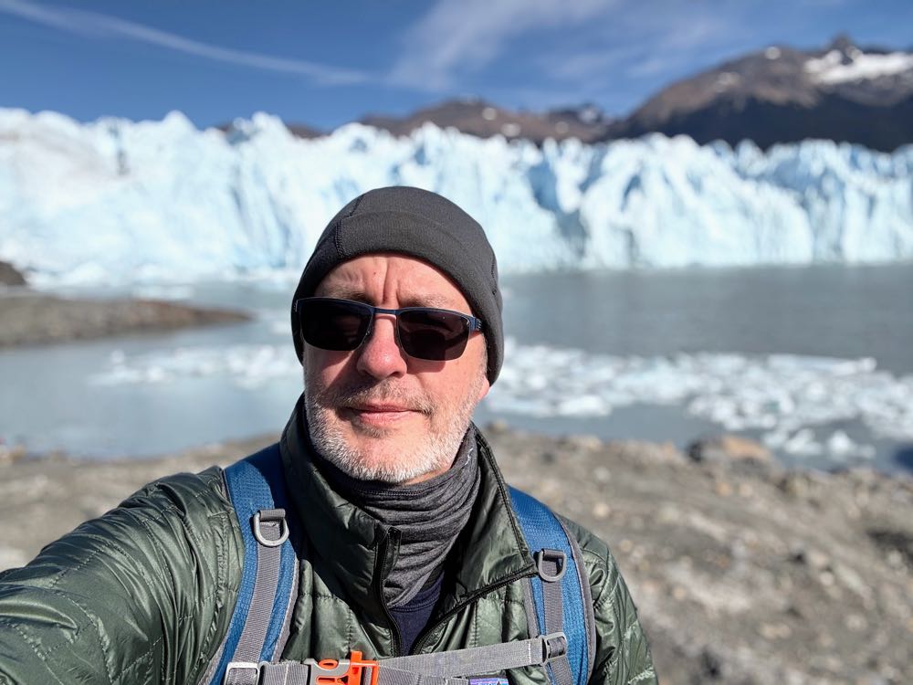 Kevin in a knit cap and sunglasses in front of the Perito Moreno glacier