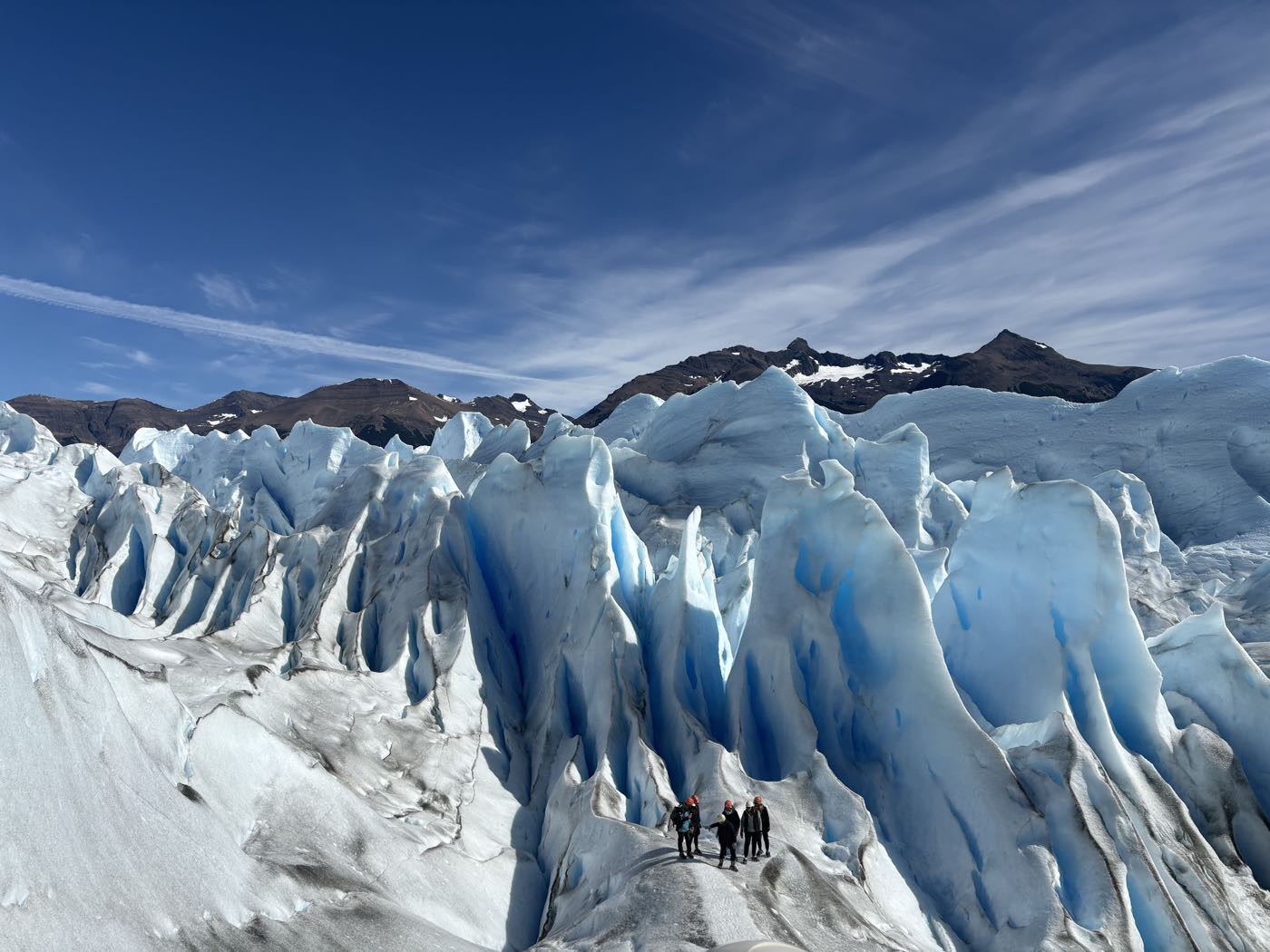 A small group of hikers on the blue ice of the Perito Moreno glacier
